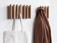 a coat rack and tote bag hanging on a wall