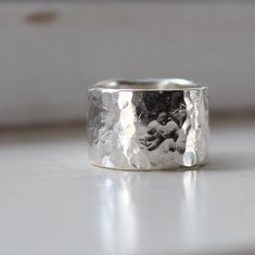 PLEASE NOTE: Personalized and customized orders are not returnable, exchangeable, or refundable. Fabrics that have been cut to order are not returnable. ***Rustic wide and heavy silver ring. It's sterling silver. I designed this for myself because I wanted a simple, rustic, thicker wide band to wear on my index finger. But this ring is truly unisex - perfectly simple minimal style for a man or woman. The ring is a full 1/2" wide and 1.25mm thick. It's intricately hammered to enhance the reflecti Hand Forged Silver Ring With Thick Band, Hand Forged Sterling Silver Wide Band Ring For Anniversary, Silver Hand-forged Wide Band Ring For Anniversary, Hand Forged Sterling Silver Rings With Thick Band, Hammered Sterling Silver Wide Band Ring Gift, Handmade Sterling Silver Wide Band Promise Ring, Sterling Silver Jewelry With Thick Band, Hand Forged Thick Band Wide Ring, Hand Forged Wide Band Ring As Gift