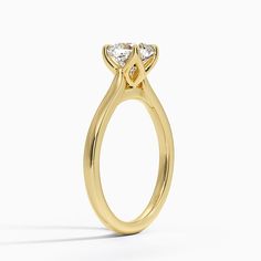 a yellow gold engagement ring with two pear shaped diamonds on the top and side view