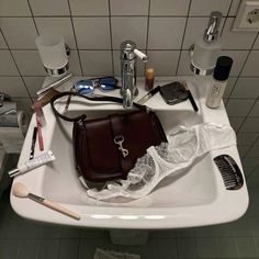 a bathroom sink filled with toiletries and personal care items on top of the sink