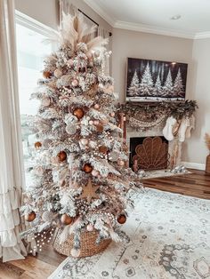 a white christmas tree in a living room with gold ornaments on the top and bottom