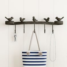 a blue and white striped tote bag hanging from a hook with birds on it