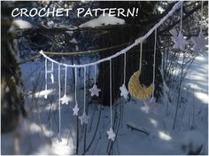 some white and gold decorations hanging from a tree in the snow with stars on it