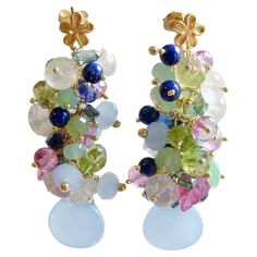 After this harsh and snowy winter, everyone is ready for the happy colors of spring and these perennial favorite earrings don’t disappoint. This riot of happy gemstones mimics the beautiful colors found amongst the happy-faced Pansy flowers of early spring for a jaw-dropping effect. Light and gorgeous chalcedony, Alexandrite topaz, rose quartz, lapis, kyanite & peridot - all cascade toward the dangling smooth blue chalcedony focal beads. This medley of Spring colors is accented by beautiful hand-carved pink sapphire leaves. Delicate gold vermeil dogwood post-style earrings, further enhance the abundant floral theme of these earrings. This cacophony of colors represents the ultimate transition earrings from a long Winter to a hopeful Spring. The beautiful blue, green and pink colors are a d Pansy Flowers, Effect Light, Pot Pourri, Snowy Winter, Focal Beads, Floral Theme, Long Winter, Blue Chalcedony, Quartz Rose