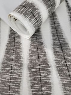 a white and grey striped wallpaper with black lines on the bottom half of it