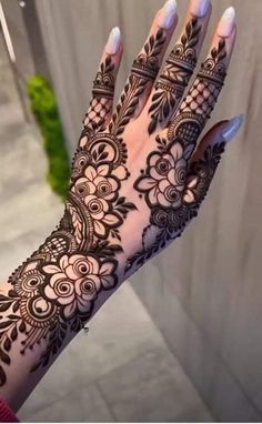 a woman's hand with henna tattoos on it