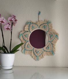 a potted plant sitting next to a mirror on a wall