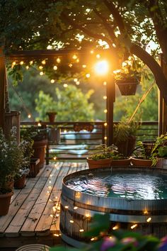 an outdoor hot tub surrounded by potted plants and trees with lights strung around it