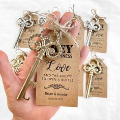 a person holding a key to each other in their hand with tags on it that say love and the ability to open a bottle