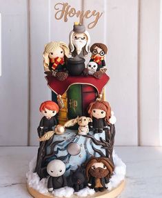 a harry potter birthday cake with hogwart's family on top and the words happy written above it