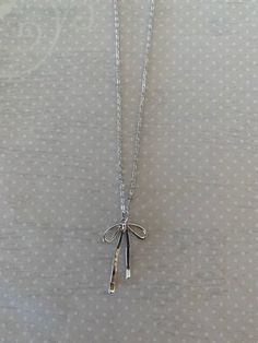 "Sleek and pretty silver tone bow knot necklace.  Simplistic design makes it a versatile piece for any outfit.   Pendant measures 1 1/4\" L X 3/4\" W and is on an 18\" chain.   ★ Want to see more?  Please visit my shop at: https://www.etsy.com/shop/DesignsByPeg" Silver Jewelry With Satin Bow For Gifts, Silver Jewelry With Satin Bow As Gift, Adjustable Silver Necklace With Ribbon, Silver Adjustable Necklace With Ribbon, Silver Sterling Silver Necklace With Bow, Dainty Silver Necklace With Bow, Adjustable Silver Necklace With Bow, Minimalist Silver Jewelry With Bow, Bow Pendant