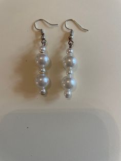 These pearl earrings are thoroughly sanitized with rubbing alcohol. On the earrings there are big pearls and little pearls. This product is made with love and care by Beaded Necessity. I appreciate you helping my small business. If you have any questions or would like to personlise this item please email me. White Beaded Dangle Pearl Earrings, Pearl White Dangle Beaded Earrings As Gift, Pearl White Dangle Beaded Earrings For Gifts, Pearl White Dangle Earrings With Pearl Charm, White Pearl Charm Drop Earrings, Big Pearl, Rubbing Alcohol, Favorite Jewelry, Jewelry Earrings Dangle