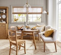 a dining room table and chairs in front of a window