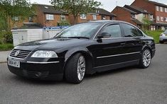 a black car parked in front of some houses