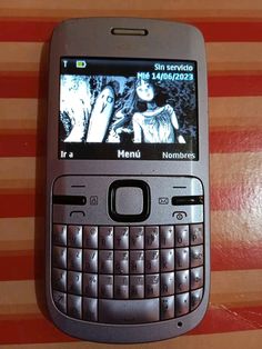 a cell phone sitting on top of a table next to a red and white striped wall