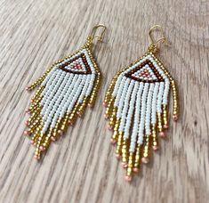 white and gold beaded earrings on wooden table