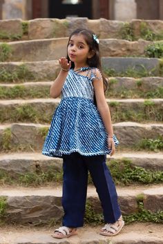 "Perfect for summer weddings and festivals this lehengha and top (set of 2) is an eye turner. Shouting with oodles of comfort during the festivities this cotton peplum suit is going to make your little one feel like herself while enjoying the festive season. Kurta - Blue leheriya with silver top, off shoulder look with tie ups on 1 shoulder. Payjama - Navy blue payjama makes it a comfy wear for your little ones as it comes with elasticated waist with drawstring for easy wear.   Fabric - Cotton C Spring Cotton Anarkali Palazzo Set, Spring Anarkali Cotton Palazzo Set, Cotton Party Dresses For Eid, Blue Cotton Salwar Kameez For Summer, Cotton Pant Set With Dupatta For Eid, Cotton Bandhani Print Sets For Spring, Cotton Anarkali Party Dress, Cotton Anarkali Lehenga For Navratri, Fitted Cotton Pant Set With Dupatta