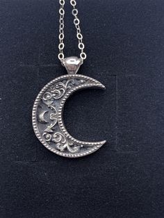 "A crescent shaped moon with a solid bail. Inside the moon is a floral scrollwork pattern. We cast this is solid sterling silver, with a dark patina to really make it pop! Pendant including bail is 26mm high and 20mm wide. This item is custom made to order. That means it may take an extra second or two to make your entire piece by hand. We try to beat shipping estimates, but its just a one woman team in this shop! Our supplier of casting grain uses SCS-certified 100% recycled metal. We make ever Moon Pendant Necklace Silver, Silver Half Moon Jewelry Engraved, Silver Half Moon Engraved Jewelry, Vintage Sterling Silver Moon Phase Jewelry, Vintage Moon Shaped Sterling Silver Jewelry, Vintage Sterling Silver Moon Jewelry, Vintage Moon-shaped Sterling Silver Jewelry, Vintage Silver Jewelry With Moon Phase, Silver Oxidized Moon Shaped Jewelry