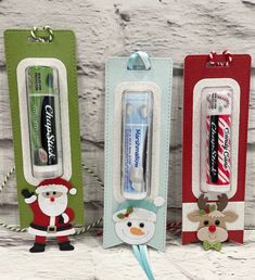 three christmas themed toothbrushes in different colors and designs, one with santa clause on it