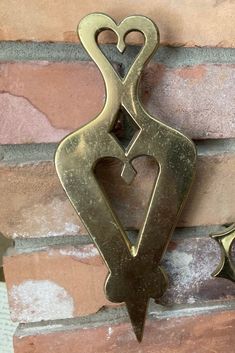 an old style door handle on the side of a brick wall with two heart shaped handles