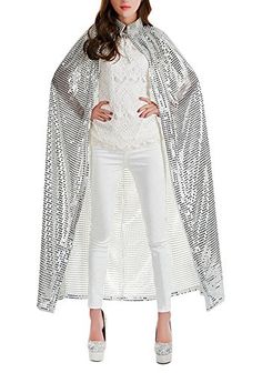 a woman wearing a white outfit and a long cape with sequins on it