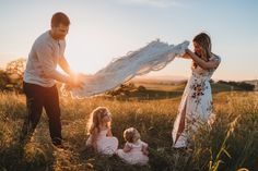 a woman and two children are playing in the grass