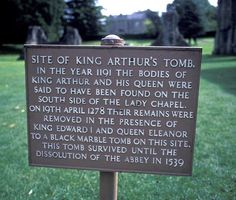 a sign in the grass that says site of king arthur's tomb