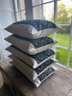 four pillows stacked on top of each other in front of a window