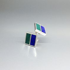 "Malachite and Lapis Lazuli square green and blue stud earrings with silver. Unique gift for her or him, friend, girlfriend, wife, September and October birthstone, 9 year anniversary. Modern and minimal square earrings combining blue Lapis with green Malachite. This beautiful earrings are worked with the technique of inlay, which means the stone is worked seamlessly into the Sterling silver. Each earring is divided into to rectangle parts divided by a 1mm silver line.  Our silver is Sterling silver and nickel free. All our stones are natural stones and our jewelry is handmade, slight differences in color and size may occur. Our inlay work is made with real stone and NOT stone dust. Please note the size specifications!  Earring size: 11 x 11 x 2 mm stone size per rectangle: 11 x 5 mm weigh 9 Year Anniversary, Lapis Jewelry, Geometrical Design, Blue Stud Earrings, Lapis Lazuli Earrings, Friend Girlfriend, Minimalist Studs, Green Malachite, Gemstone Stud Earrings