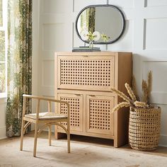 a wooden cabinet sitting next to a window with a mirror on it's side