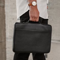 a man carrying a black briefcase on the street