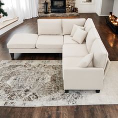 a living room with a sectional couch and rug in front of a fire place on the wall