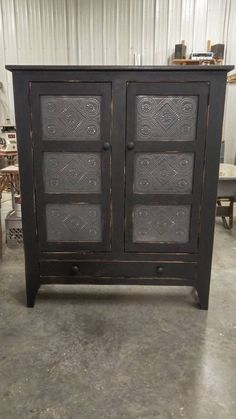 an old black cabinet with etched glass doors