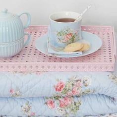 there is a tea pot and cup on the table next to a plate with cookies