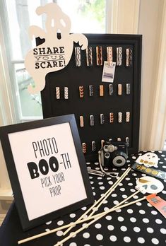 a table topped with black and white polka dot covered items next to a sign that says photo boo - tik your prop