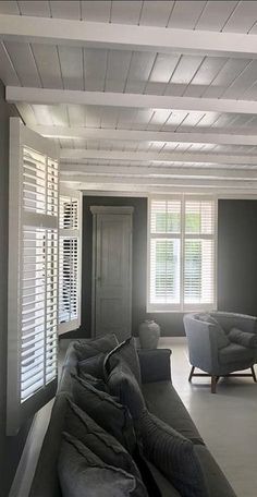 an empty living room with couches and windows