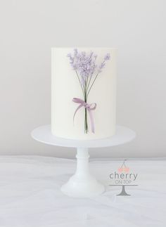 there is a white cake with purple flowers on it