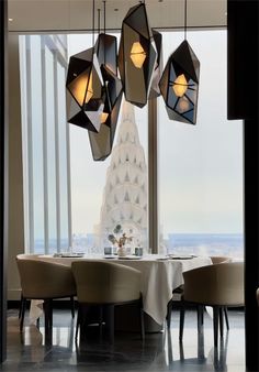 a dining room with large windows and chandeliers hanging from the ceiling