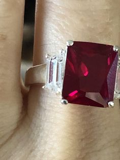 Olivia de Havilland,  icon of the Golden Age of Hollywood,  always loved rubies.   A stage and screen actress for so many years, collected rubies as soon as she could afford them.  This beautiful emerald cut simulated red ruby is perfect in cut and hue.  Size 76CT Emerald Cut Lab Red Ruby 925 Sterling SilverShips 1 business dayGift Box Red Emerald Cut Ring For Anniversary, Red Emerald Cut Rings With Accent Stones, Emerald Cut Red Ring For Anniversary, Rectangular Red Ruby Ring For Formal Events, Emerald Cut Ruby Ring For Anniversary, Rectangular Ruby Ring For Wedding, Elegant Rectangular Ruby Ring, Rectangular Red Ruby Ring For Wedding, Red Ruby Ring For Anniversary