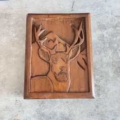 a wooden carving of a deer with antlers on it's head is shown