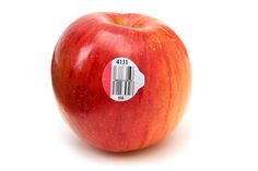 an apple with a barcode sticker on it's side, in front of a white background