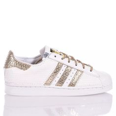 Adidas Superstar White Hive is the super glamorous custom women's sneaker. Entirely in white eco-leather with a geometric texture, featuring the iconic adidas stripes and a textured gold laminated back paired with round gold lurex laces. Adidas Superstar White Hive will also be provided with its original laces. Sporty Gold Sneakers With Perforations, Gold Low-top Sneakers With Perforations, White Leather Sneakers With Foil Embossed Logo, Geometric Texture, Zegna Shoes, Sneaker Wedge, Custom Shoes, Manolo Blahnik, High Heel Shoes