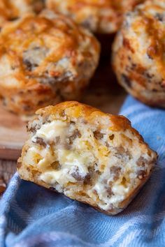 some food that is sitting on top of a blue towel and next to it are muffins