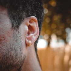 a close up of a man's ear with a gold ring on his left ear