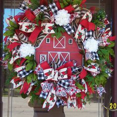 a red barn wreath with white and black flowers