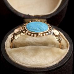 This ring was a commitment jewel. The fede motif (two clasped hands) represents the joining of hands of the couple at a marriage ceremony, a practice that dates back to ancient Rome and was known as 'dextrarum iunctio'. This fede is turquoise-colored glass, pressed in the Georgian era and set into a tricolor gold mounting with shell and flower details at the shoulders. MATERIALS: blue glass, 14k tricolor gold (tests). AGE: c. 1800 SIZE: size 6.5, can be resized; 8.4mm head, 1.3mm shank Heirloom Rings With Decorative Band, Traditional Ceremonial Intaglio Jewelry, Antique Oval Turquoise Ring Hallmarked, Antique Ceremonial Engraved Ring With Decorative Band, Antique Engraved Ring With Decorative Band For Ceremonial, Antique Engraved Ring With Decorative Band For Ceremonial Occasions, Traditional Yellow Gold Jewelry With Decorative Band, Traditional Carved Engraved Wedding Ring, Victorian Yellow Gold Carved Rings