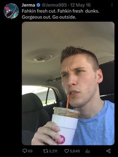 a man drinking from a straw in the back seat of a car while holding a drink