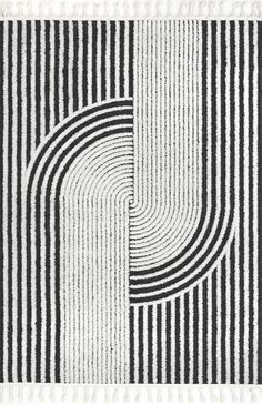 black and white striped rug with fringes on the bottom, in front of a circular design