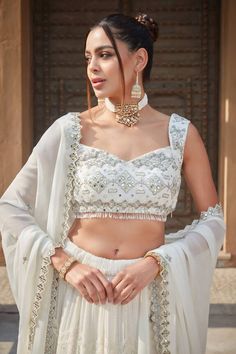 Ivory lehenga with chikankari embroidered stripe and scallop motifs embellished by sequins. Comes with mirrorwork embroidered blouse and cut-out border dupatta. - Aza Fashions Festive White Pre-draped Saree With Intricate Embroidery, White Anarkali Pre-draped Saree With Intricate Embroidery, Designer White Choli With Intricate Embroidery, White Bollywood Choli With Intricate Embroidery, White Pre-draped Saree With Intricate Embroidery For Festive Occasions, White Embroidered Choli For Reception, White Sleeveless Traditional Wear With Resham Embroidery, White Palazzo Set With Dupatta For Reception, White Palazzo Set With Intricate Embroidery For Festive Occasions