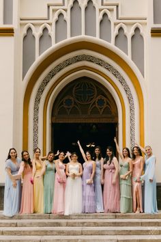 a group of women in long dresses standing on steps with their hands up and arms raised